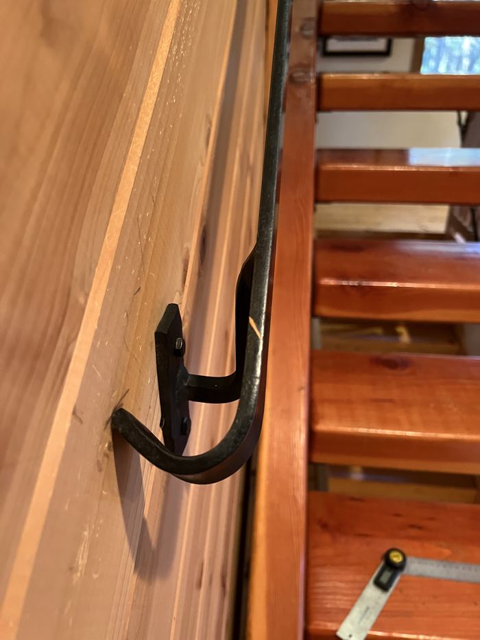 Steel handrail and wall bracket running along an interior stair