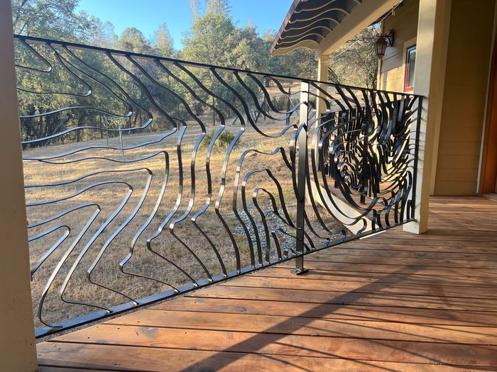Topograin porch railing seen from the deck, looking out over a dry field